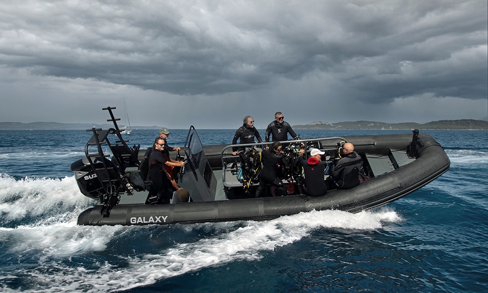 Galaxy RIB with dive crew and equipment underway at speed in open water.