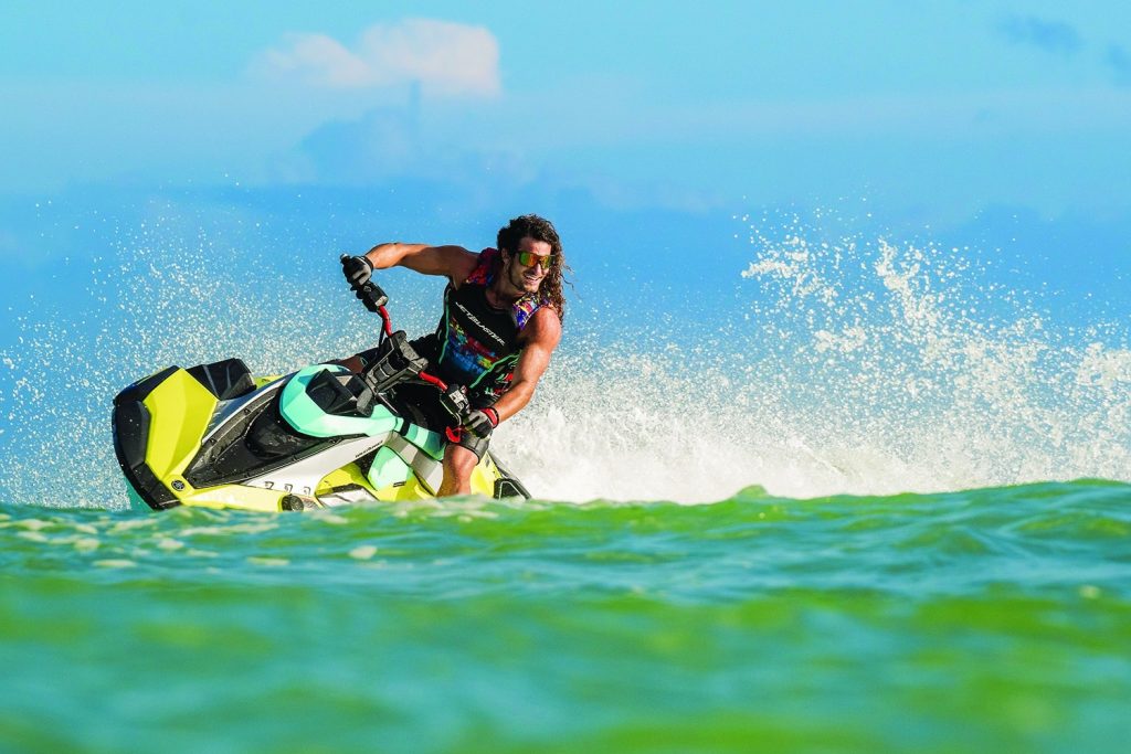 Man with muscles and longer hair riding a turn on a Yamaha JetBlaster Pro jet ski