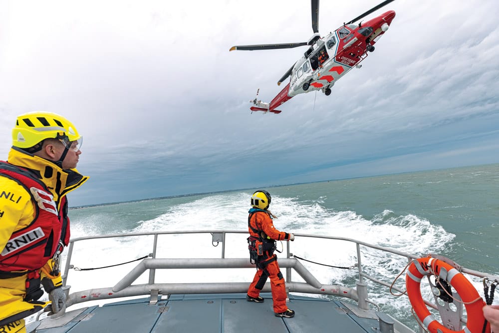 RNLI Relief Tamar lifeboat Edward and Barbara Prigmore 16-10 undertaking a training exercise with HM Coastguard helicopter for the RNLI working with helicopters film. Crew on deck wearing new Petzl helmets.