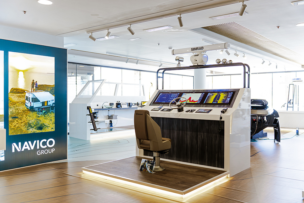 View inside Navico's Experience Centre with a boat console in the foreground set up wiht electronics to try