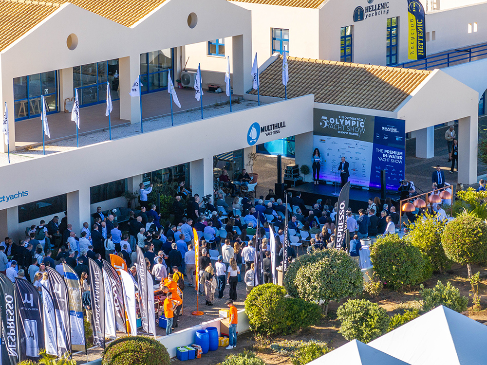 Aerial view of the Olympic Yacht Show 2025 opening ceremony at Olympic Marine, Lavrio, with attendees, banners, and event stage.