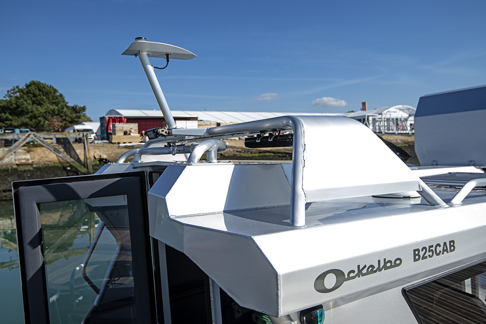 Ockelbo B25 CAB cabin roof showing radar mount, grab rails and clean aluminium finish under clear blue sky.