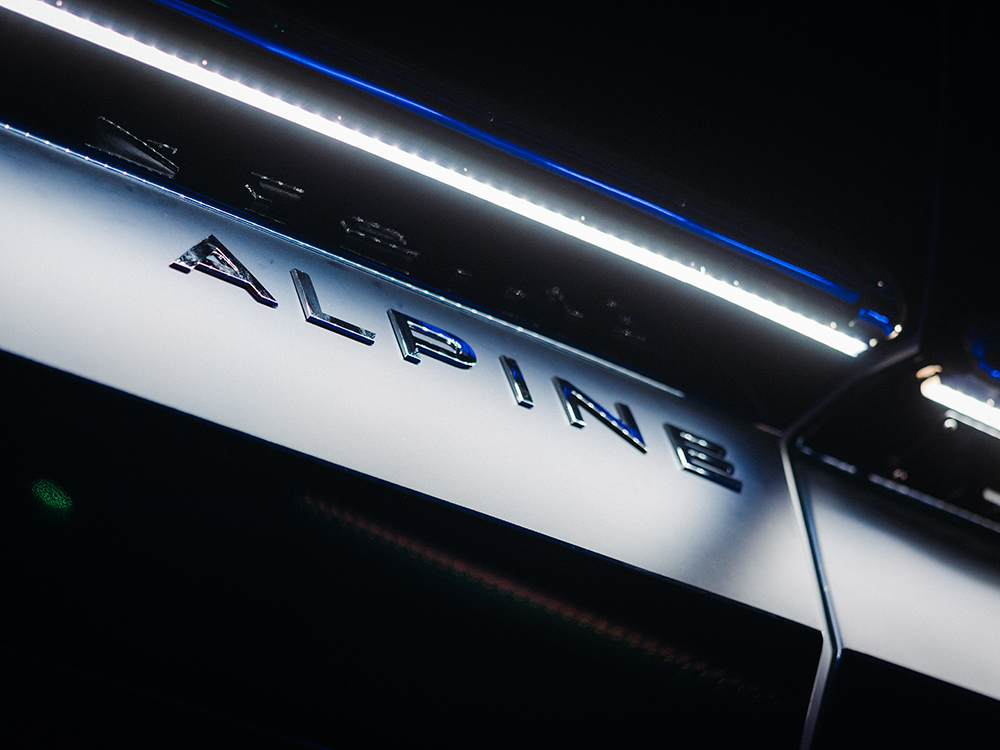Close-up of illuminated Alpine branding on a sleek metallic surface