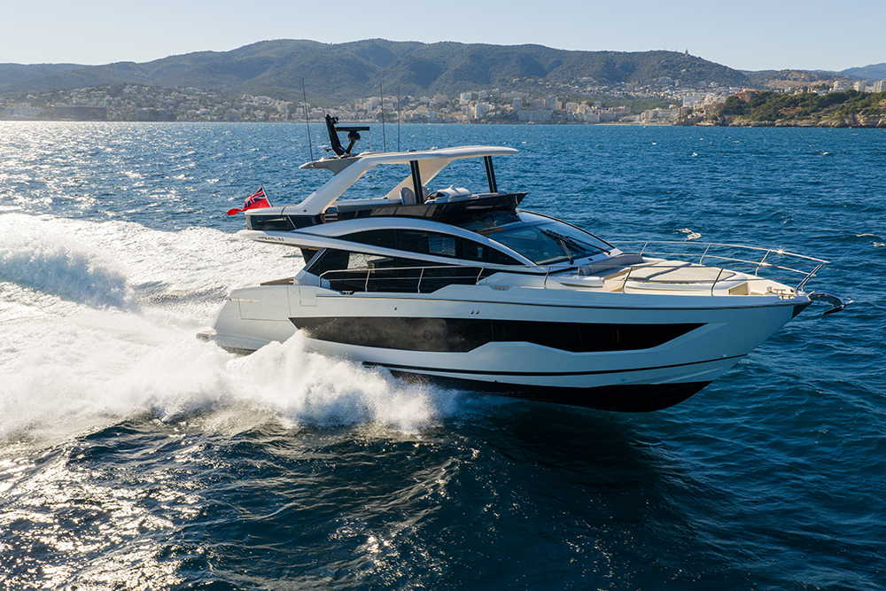 Pearl 63 motor yacht underway at speed, showing flybridge and hull windows during sea trials in coastal waters.