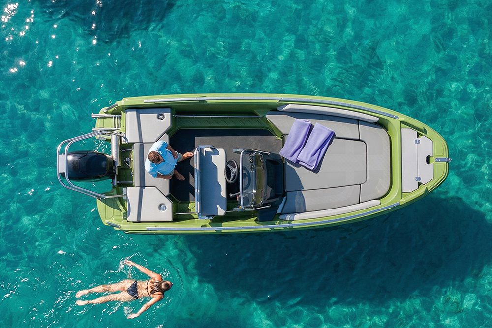 Overhead view of ROTO Nautica Hydra 460 motorboat in turquoise water, showing open deck layout with a swimmer alongside.